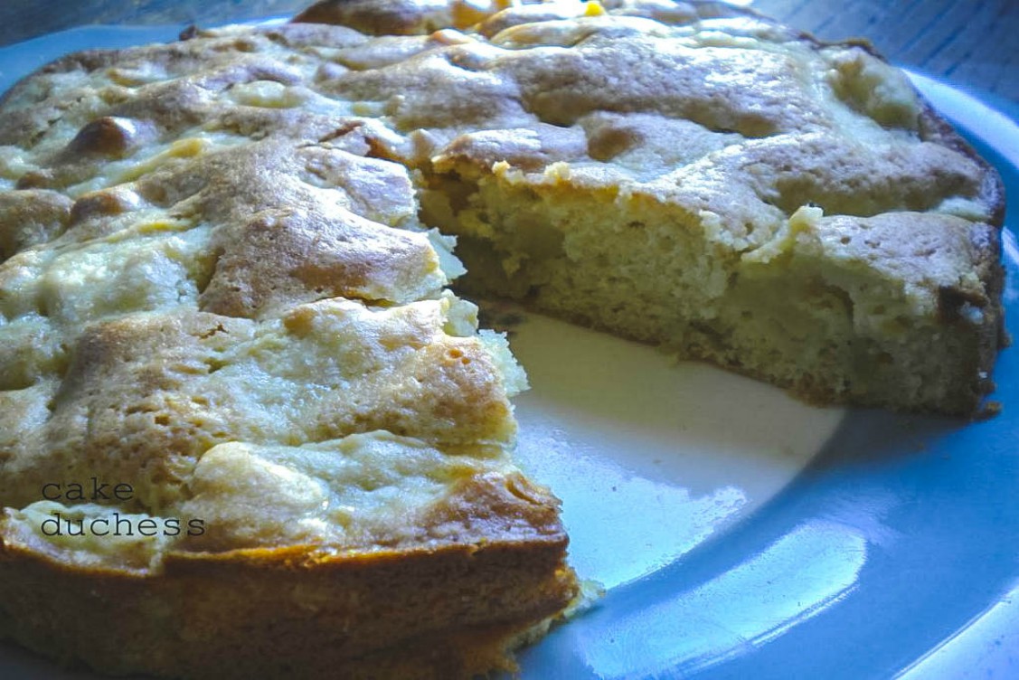 side image of apple cake with a piece cut out on serving plate