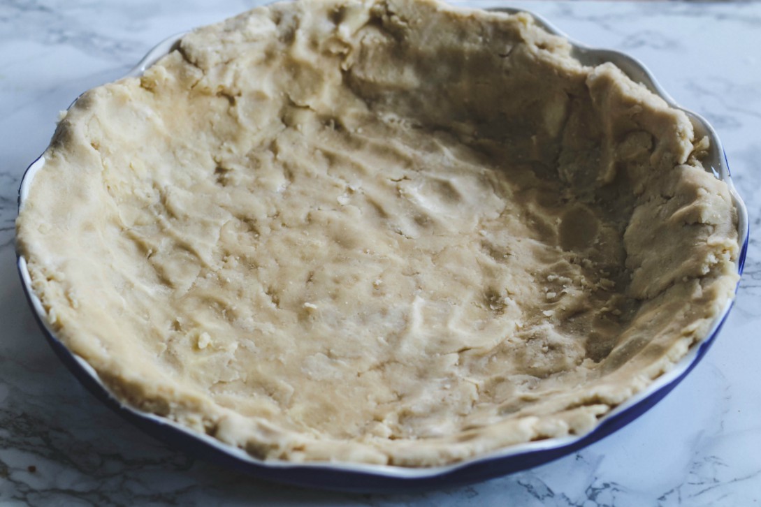 overhead image of homemade pie crust in pie plate