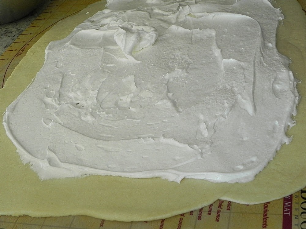 overhead image of spreading meringue on dough