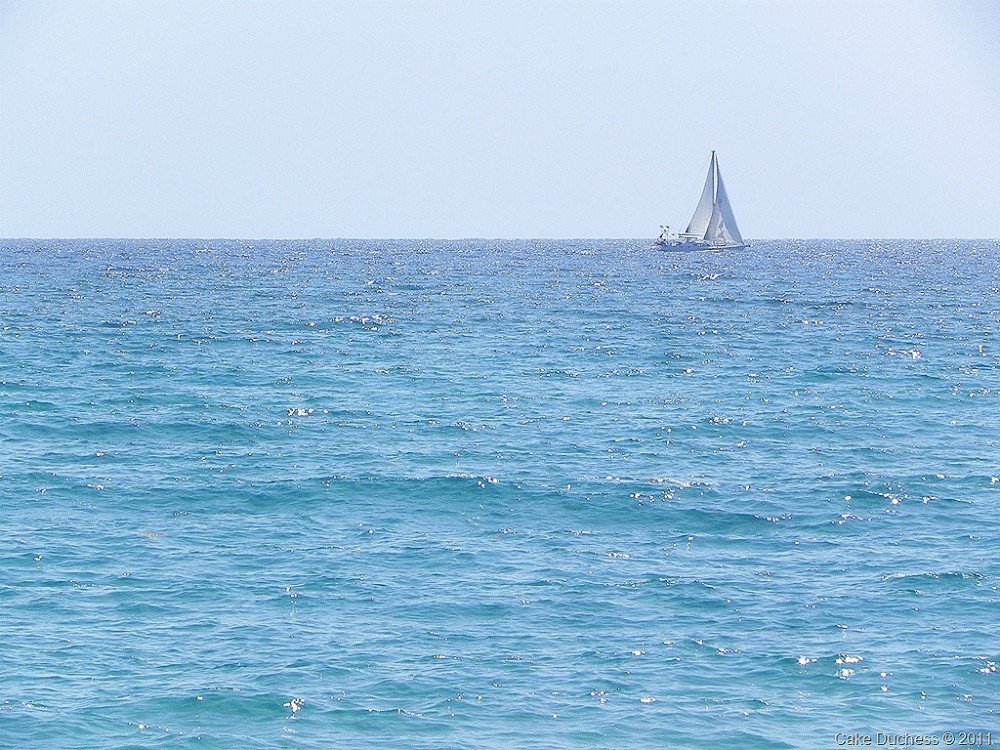 overhead image of sailboat on blue ocean