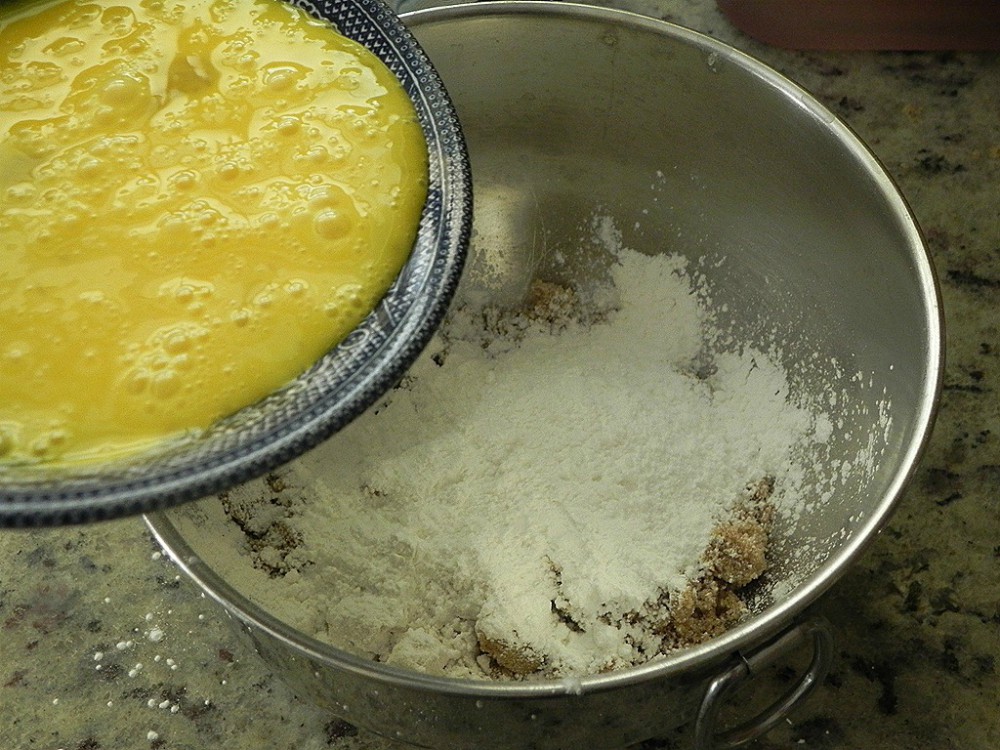 overhead image of whipped egg yolks and a bowl with flour