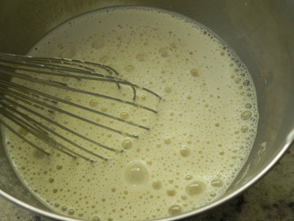 overhead image of hot milk in a whipped egg mixture