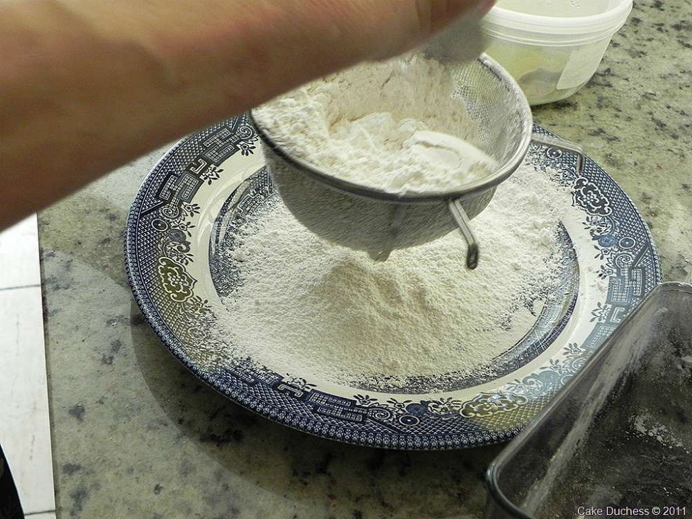 overhead image of flour sifting in a dish