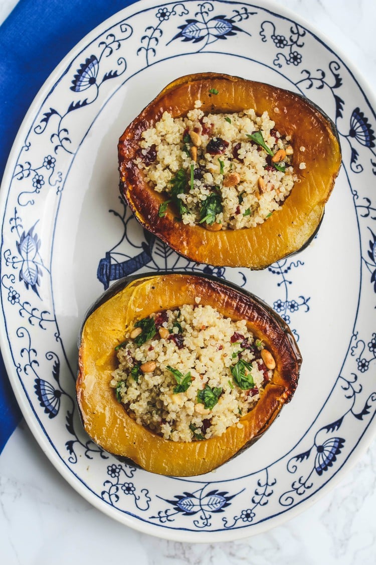 Overhead image of two halves of Stuffed Acorn Squash with Quinoa, Dried Cranberries and Pinoli.