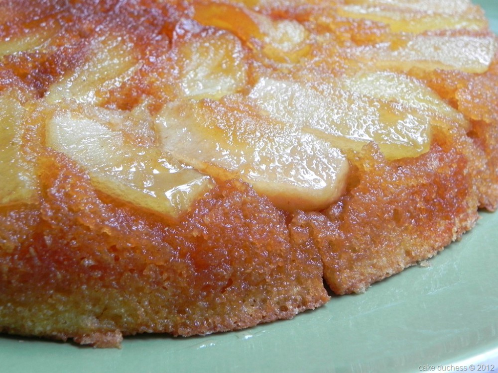 close up image of easy apple upside down cake on a green plate. 