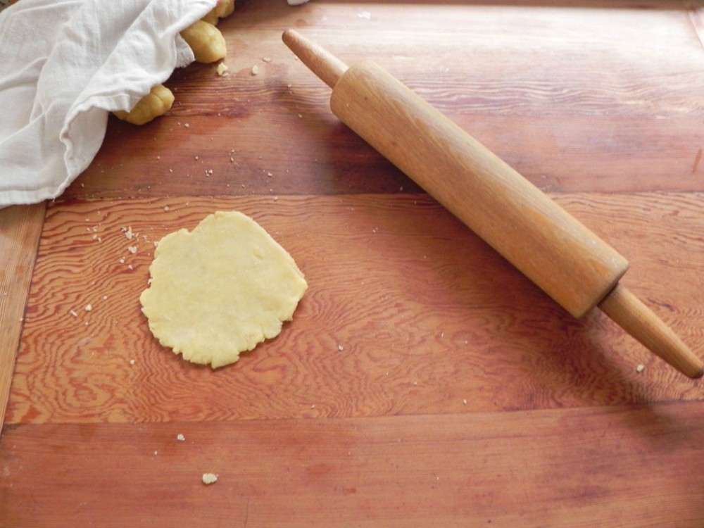 overhead image of portion of dough and rolling pin