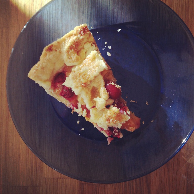 overhead image of slice of cran apple pie on a blue plate. 