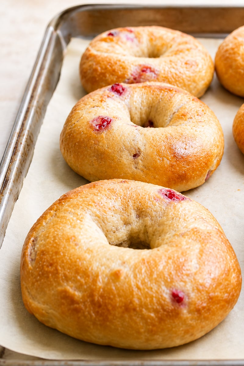 Three golden-brown Strawberry Bagels with visible bits of red fruit.