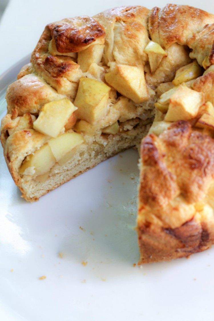 overhead image of apple harvest bread sliced on a white plate