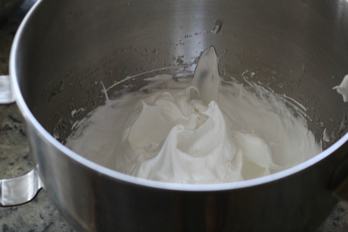 overhead image of whipped egg whites in a mixing bowl