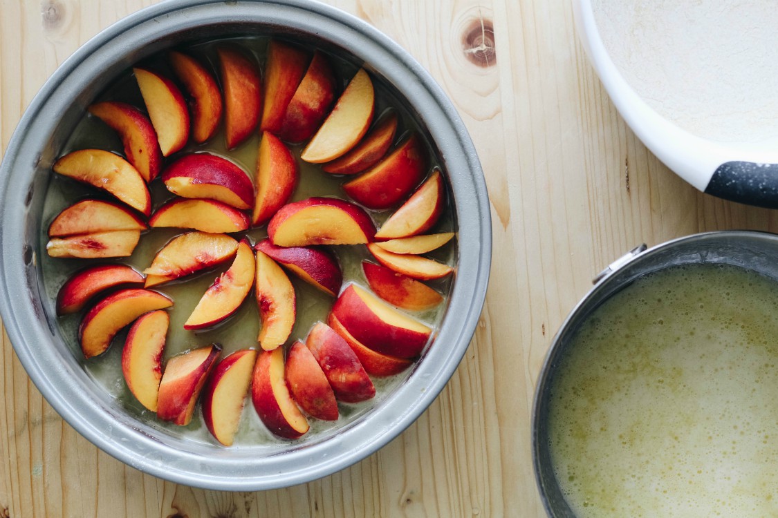 overhead image of making vegan peach polenta cake.