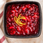 Square bowl of Italian cranberry sauce garnished with lemon zest.