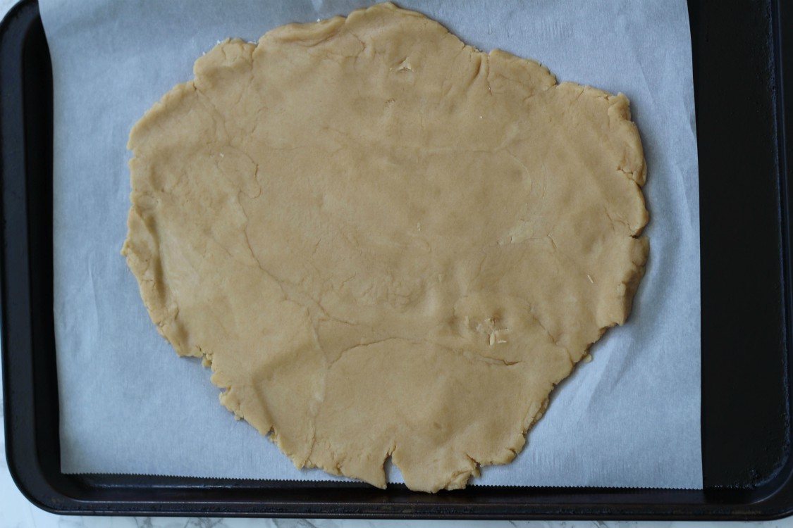 overhead image of dough rolled out on baking tray