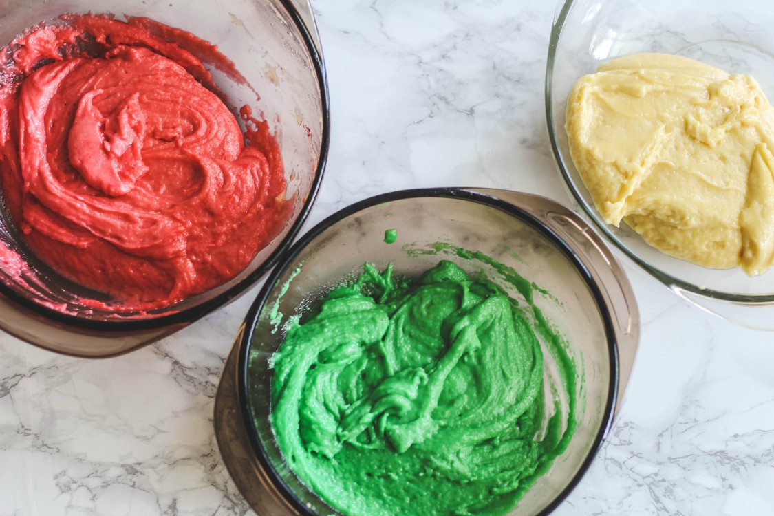 overhead imgae of colored dough in bowls