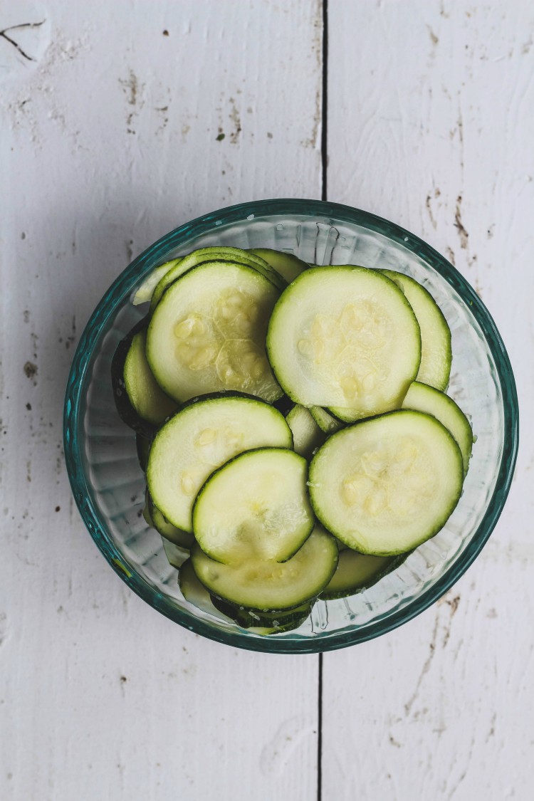 overhead image of sliced zucchini in a glass dish