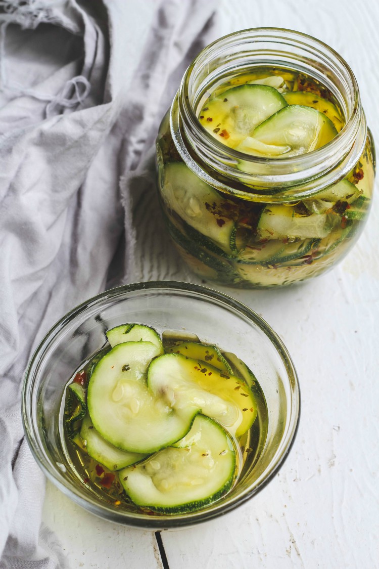 overhead image of marinated zucchini in glass jars