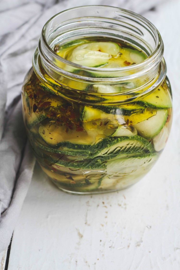 overhead image of marinated zucchini in glass jar