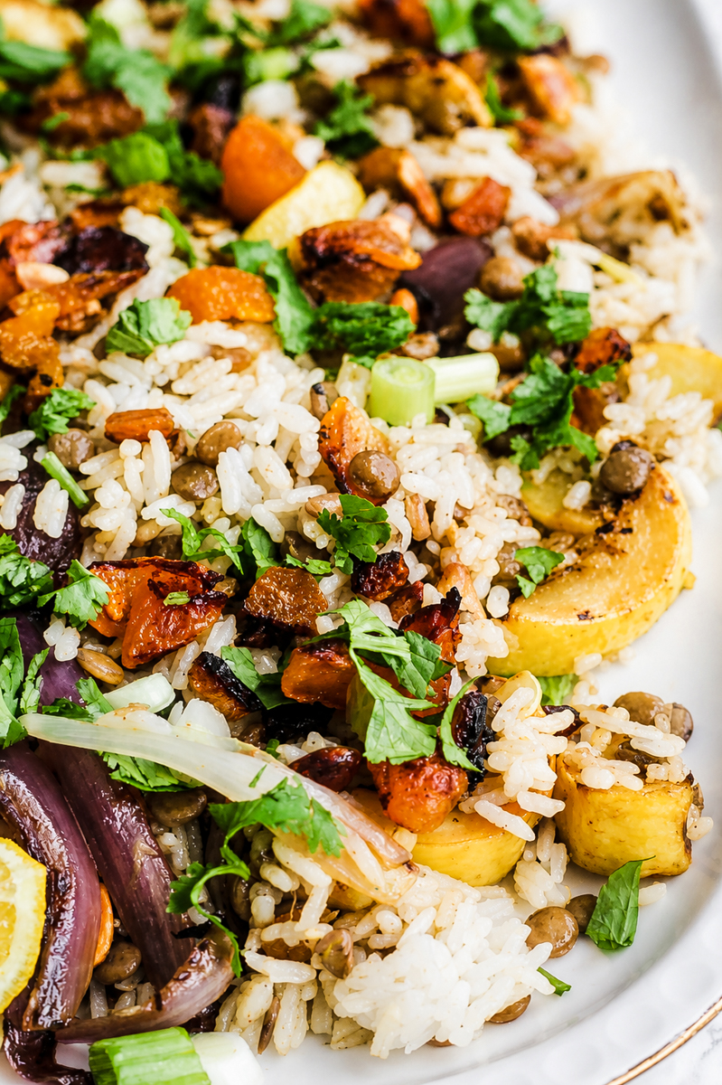 Vegan biryani salad in a large serving bowl with crispy fried shallots, cilantro, and colorful dried fruit