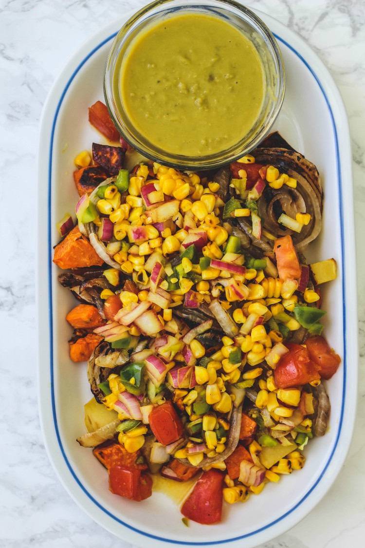 overhead image of roasted potatoes with sweet corn relish witha pea sauce on a white plate