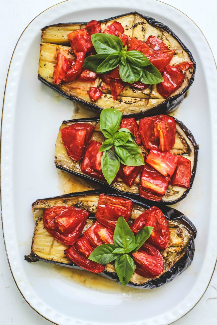 overhead image of sheet pan eggplant and tomato bake on a white plate.