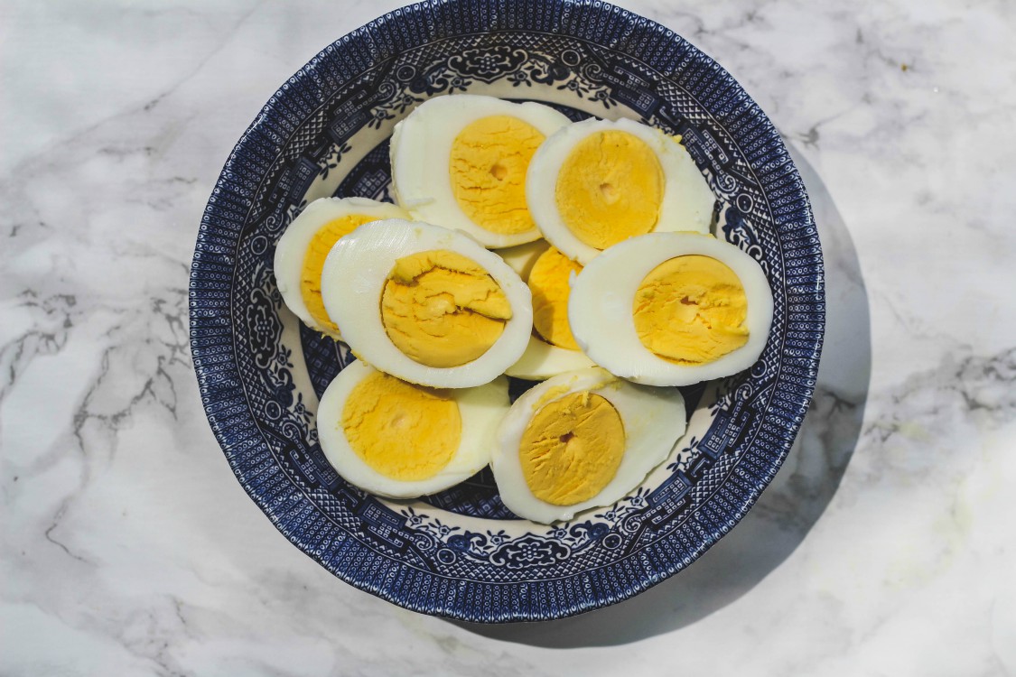 overhead image of hard boiled eggs in a blue plate