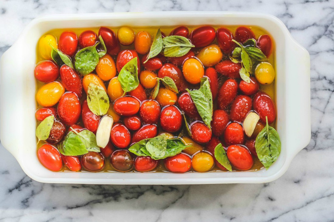 overhead image of cherry tomato confit in a white casserole