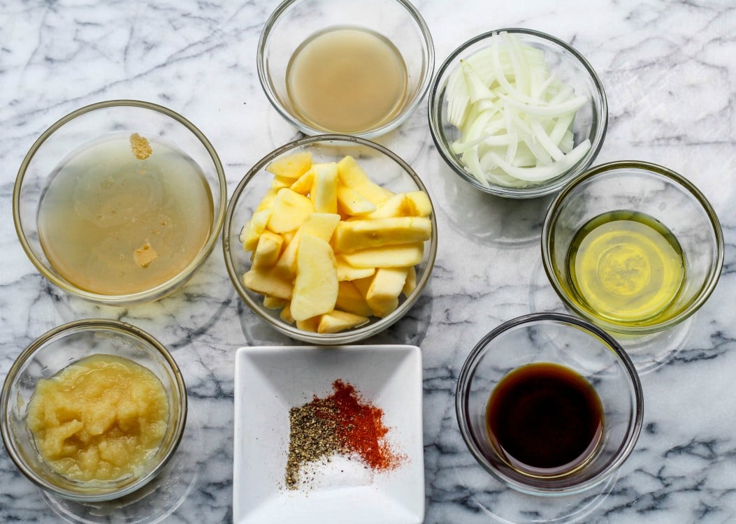 overhead image of ingredients to make an apple and onion sauce in glass bowls.