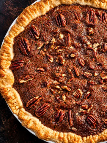 Chocolate espresso pecan pie with a pecan-half border on a holiday table
