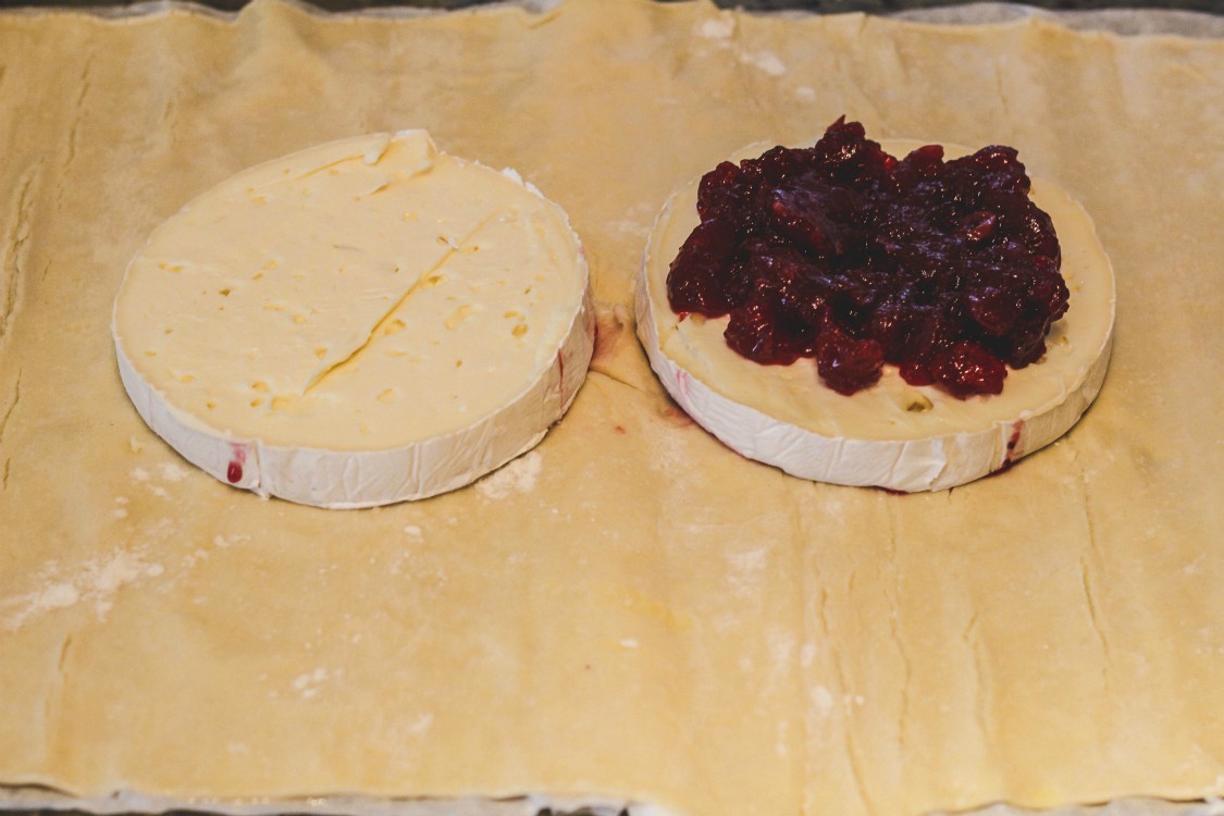 overhead image of brie with cranberry sauce on puff pastry sheet