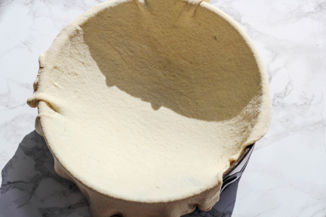 overhead image of dough stretched over a springform pan 