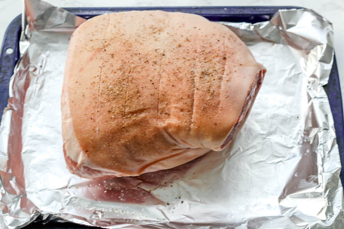 image of pork shoulder on foil lined baking sheet