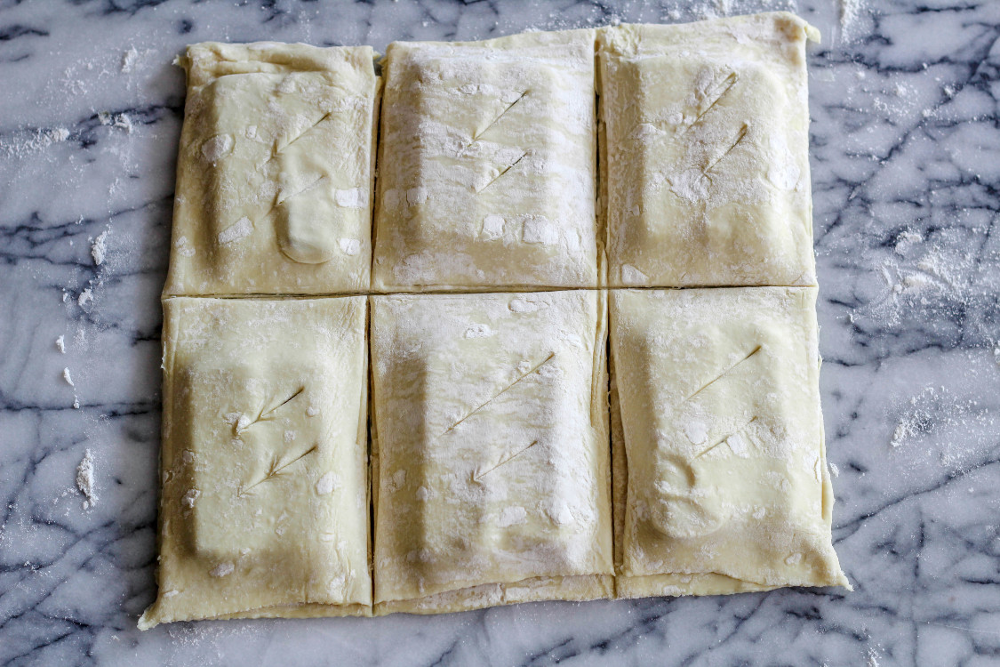 overhead image of puff pastry squares on marble counter