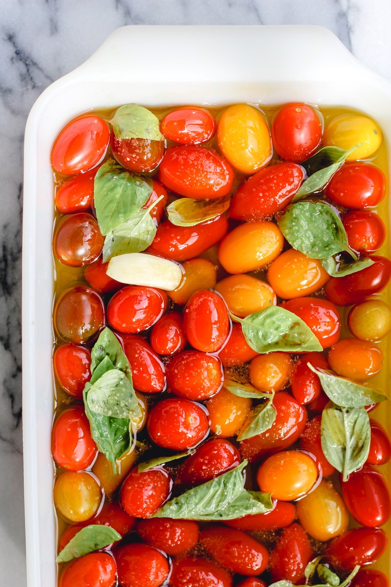 overhead image of making cherry tomato confit in a white baking dish