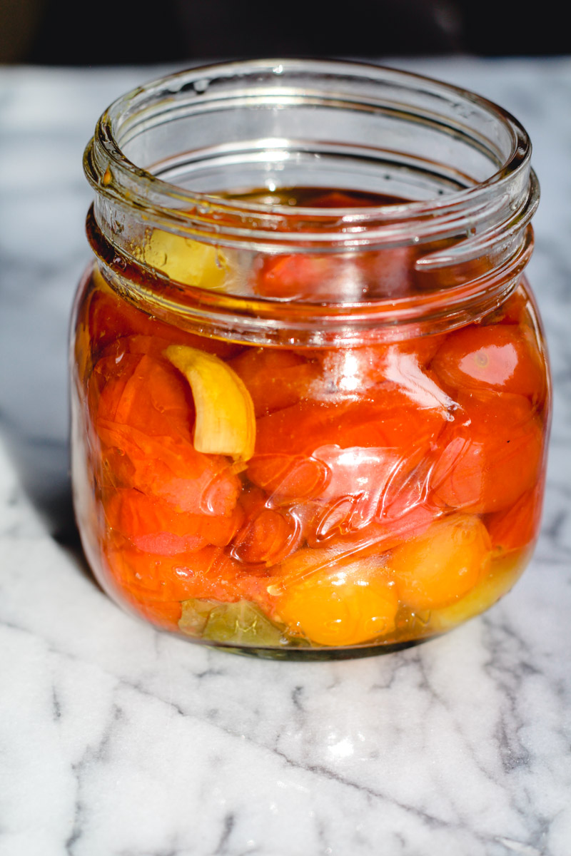 image of tomatoes in a glass jar on a marble background