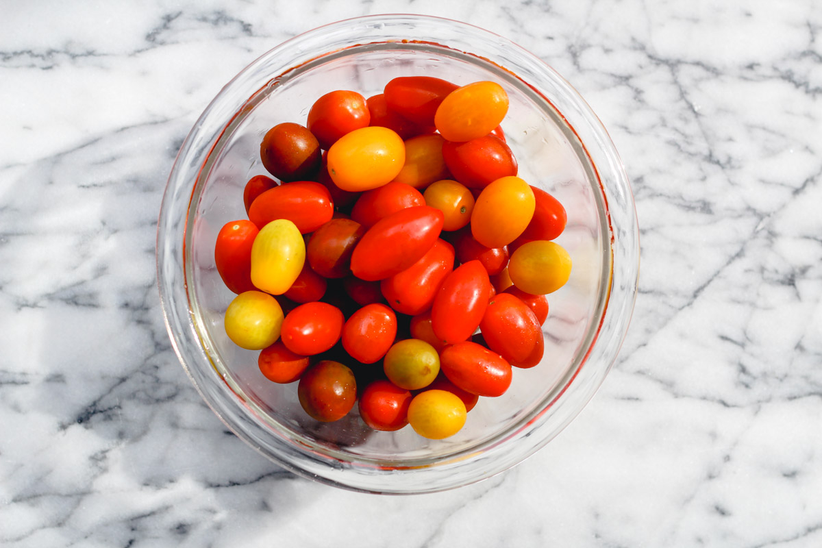 overhead image of cherry tomatoes in a glass dish