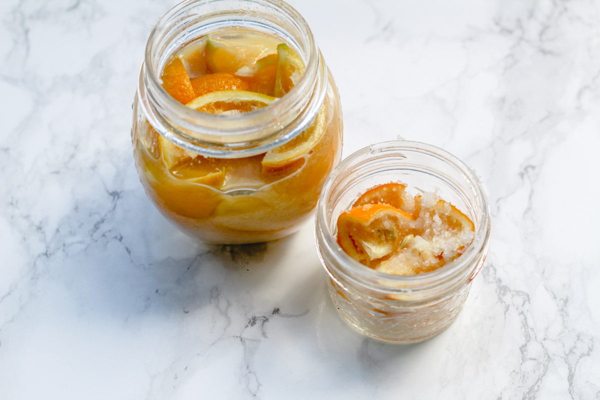 overhead image of preserved Meyer lemons in jars and a marble background