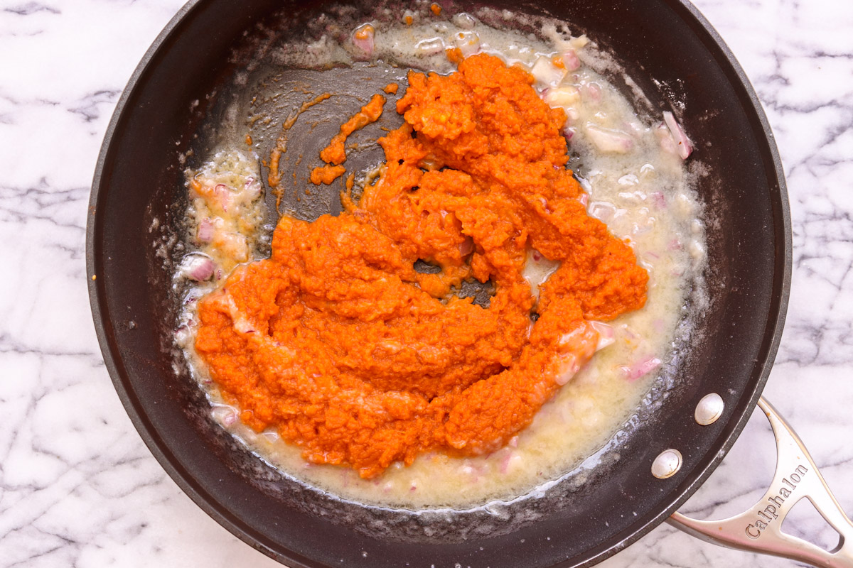 overhead image of making pumpkin sauce in a skillet.