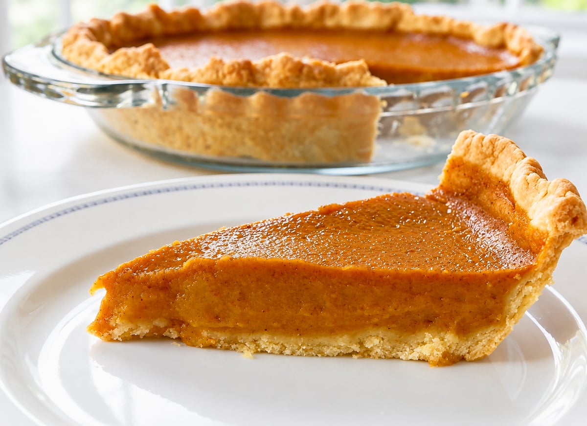 Vegan pumpkin pie topped with a pie dough letter V for vegan
