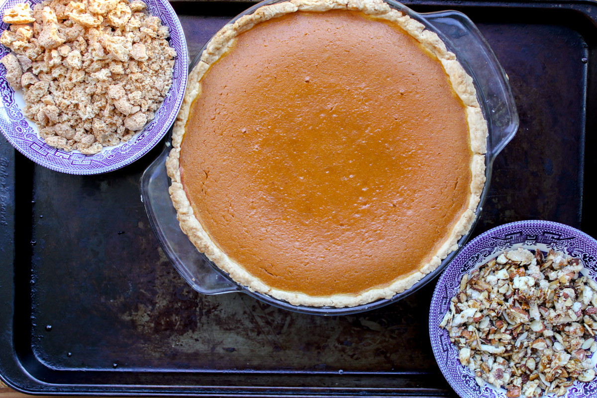 image of just baked pumpkin pie and crumbled amaretti cookies and chopped almonds 