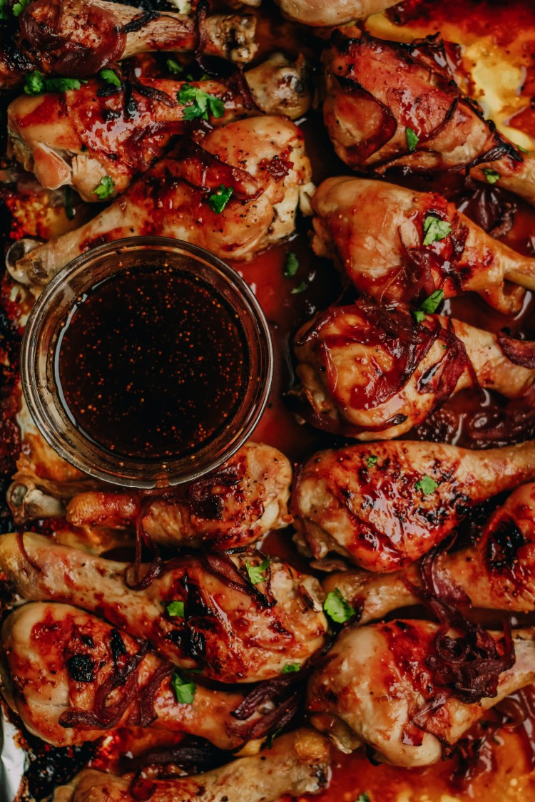overhead image of balsamic fig glazed chicken with caramelized onions on a baking sheet