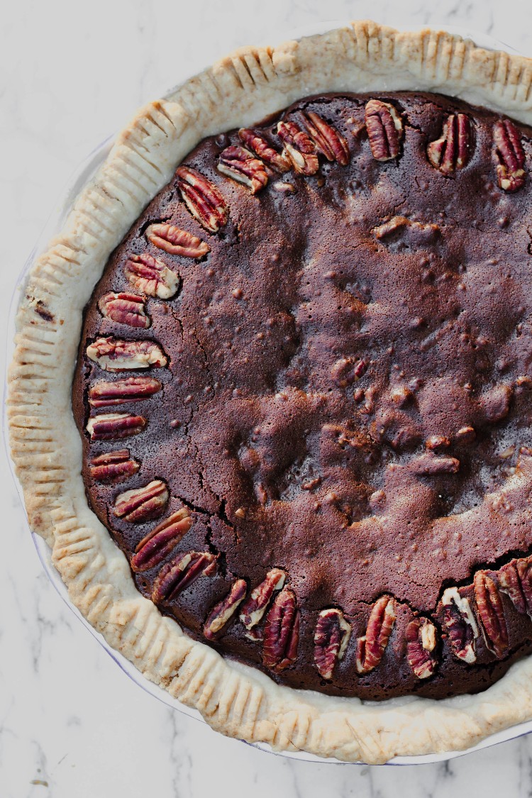 overhead image of paleo chocolate pecan pie on a marble counter