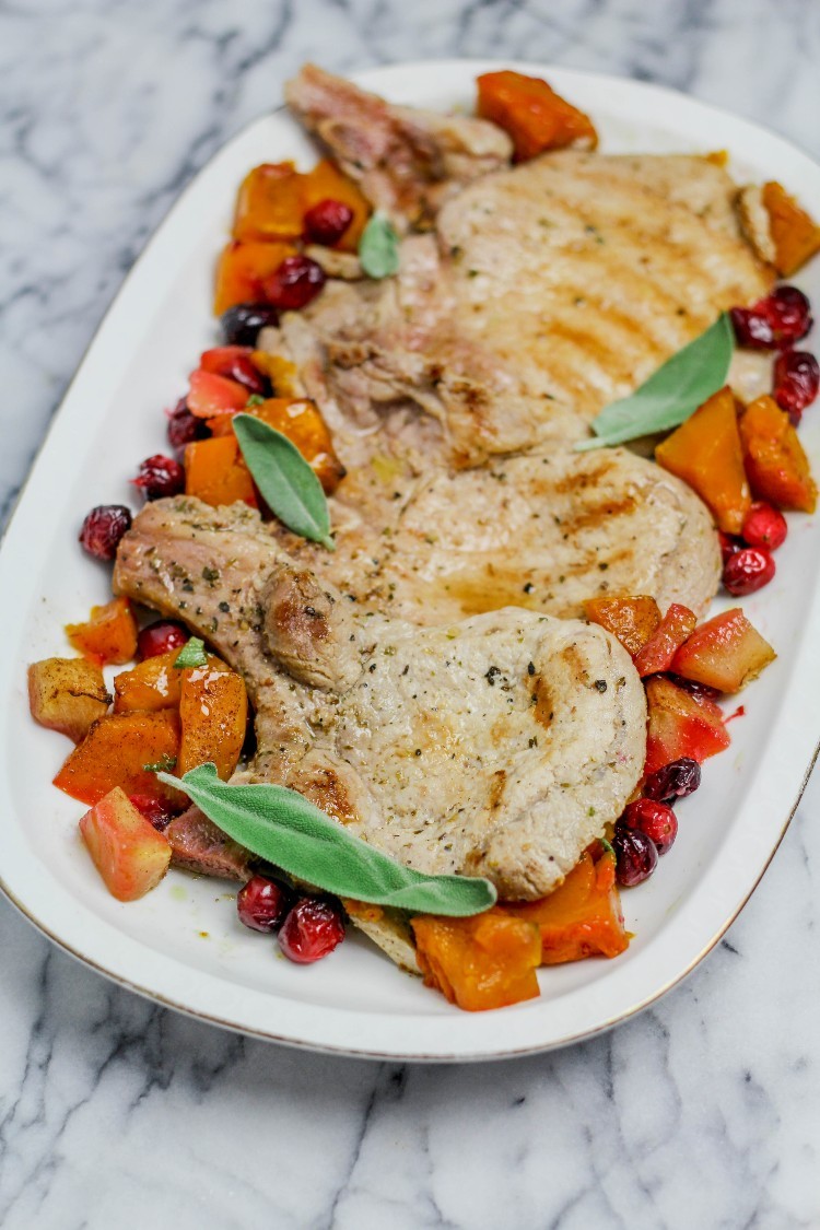 image of pork chops with pumpkin, apples and cranberries on a white plate