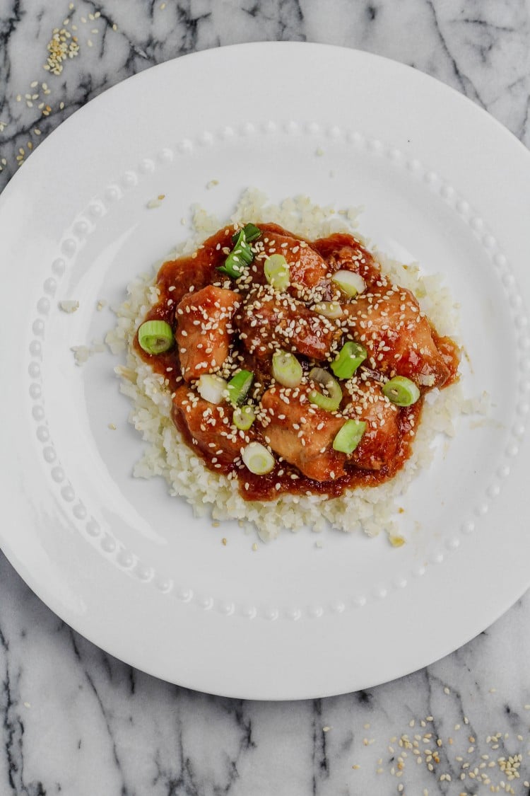 overhead image of easy slow cooker sesame chicken on a white plate 