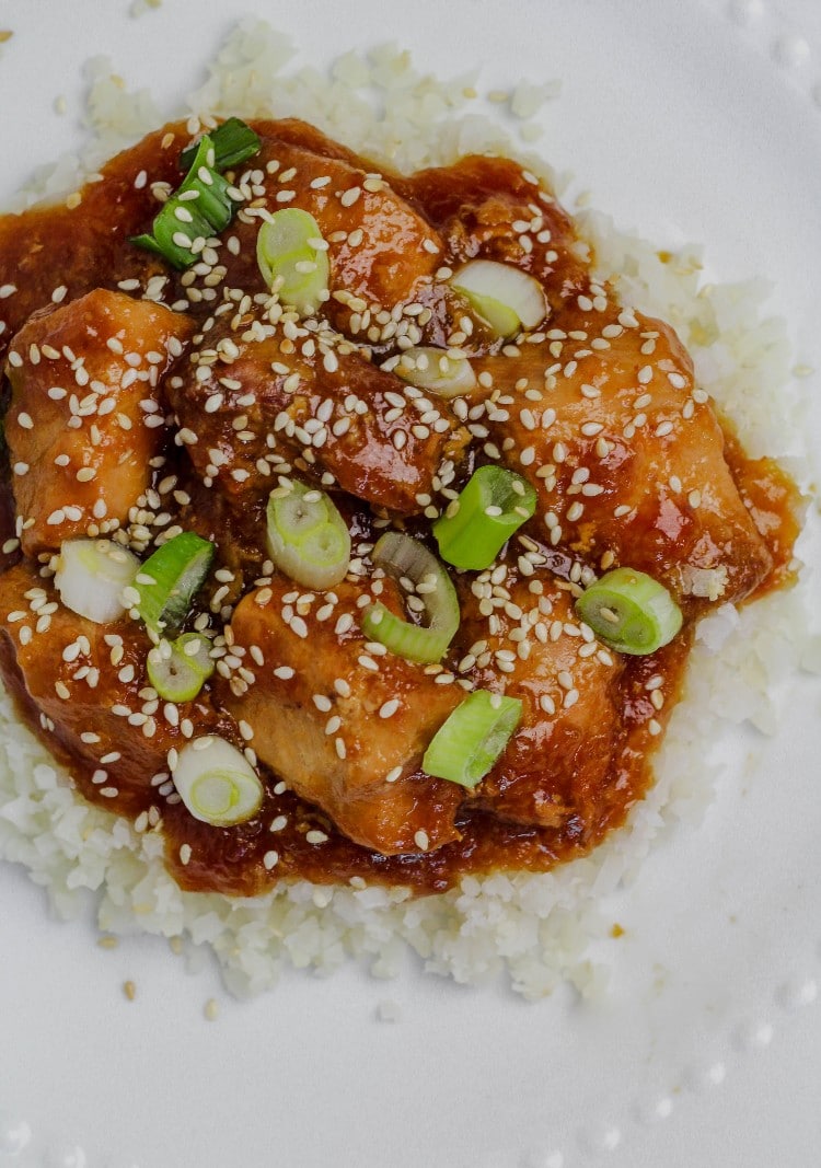 overhead image of slow cooker sesame chicken on cauliflower rice