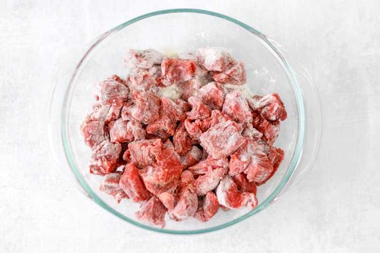 image of beef tossed in flour in glass bowl