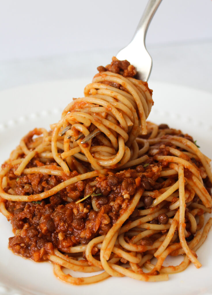 image of spaghetti on a fork with easy lentil bolognese sauce