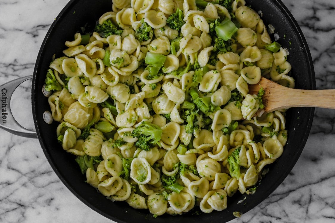 image of cooking making pasta and a green vegetable in a large skillet