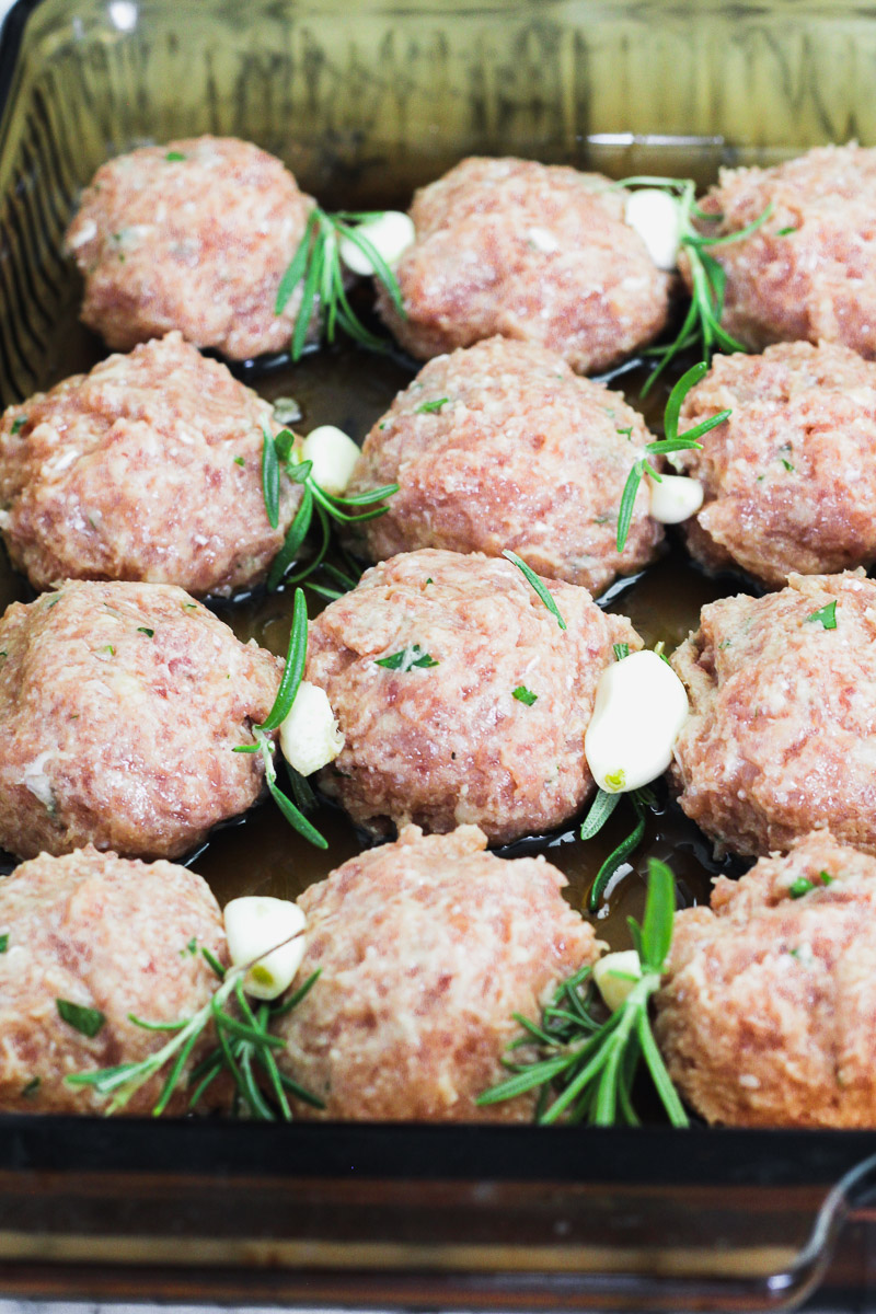 image of meatballs with rosemary and garlic in a baking dish