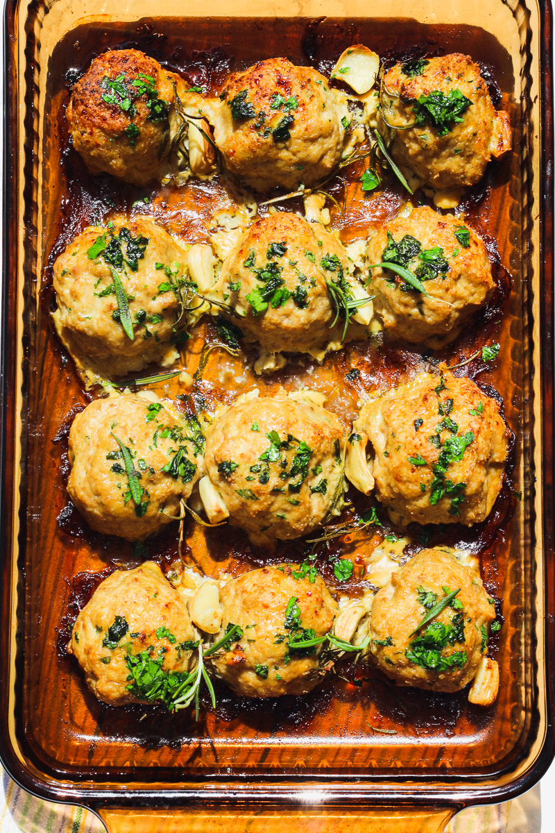 overhead image of garlic rosemary Whole30 meatballs in a baking dish