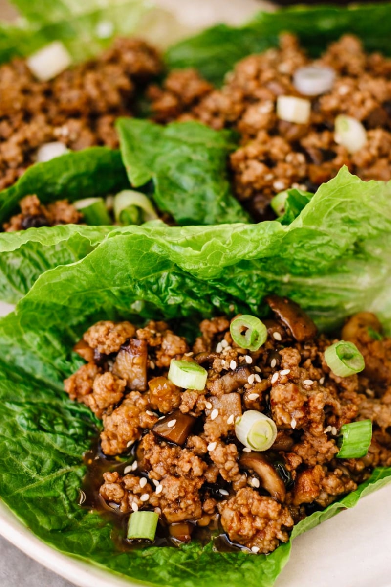 Ground chicken cooked with mushrooms, topped with sliced green onions and sesame seeds, served in fresh romaine lettuce leaves for delicious chicken lettuce wraps.